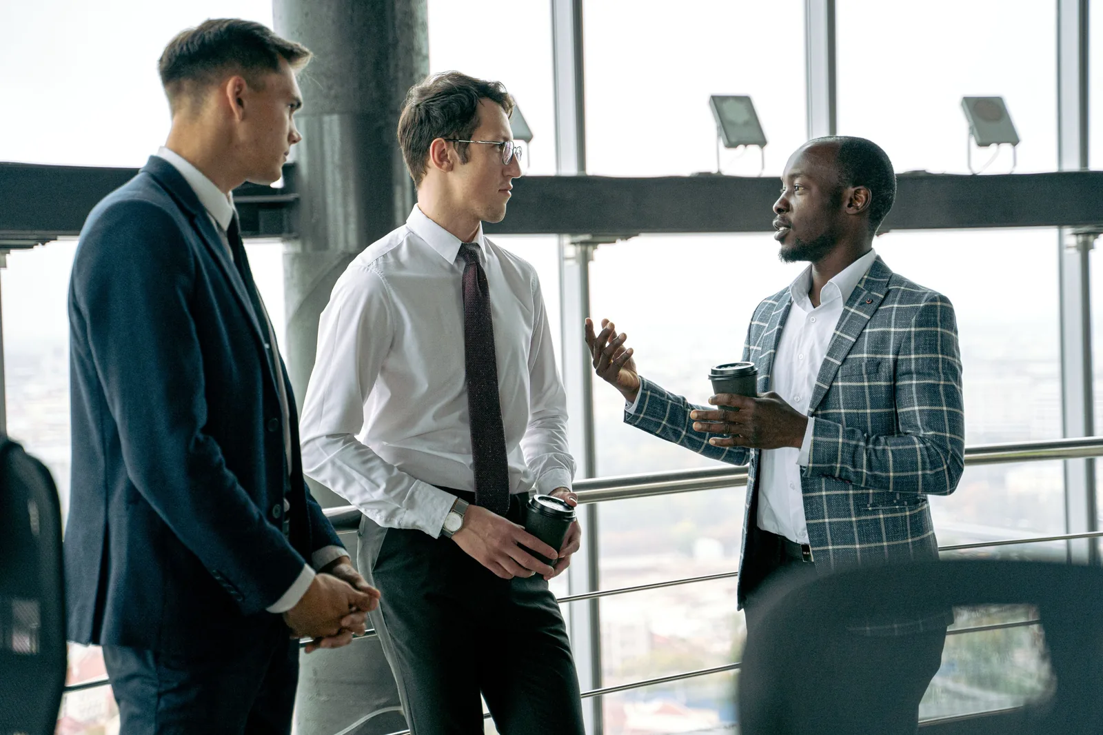 Three colleagues talking in a high-rise office